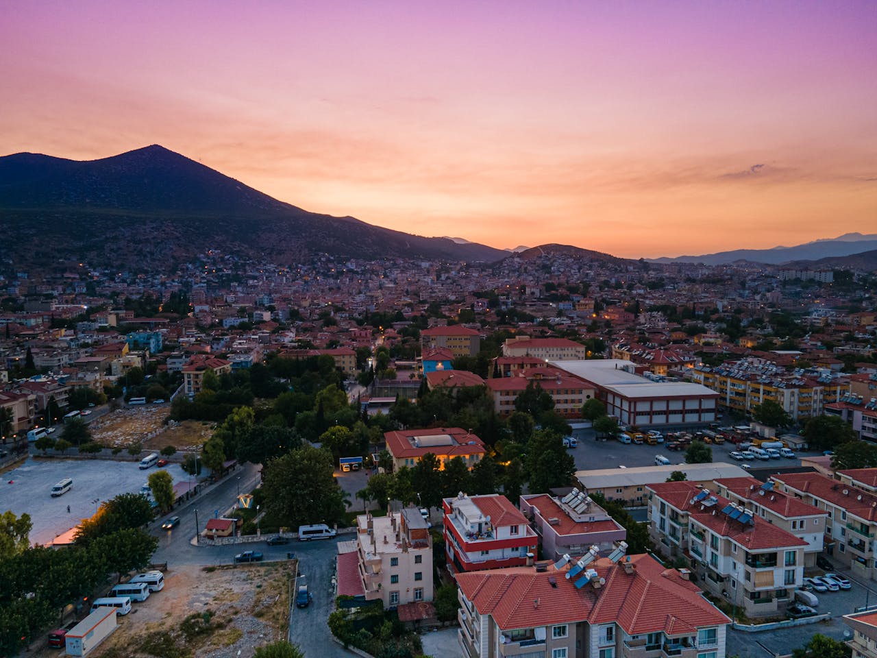 Captivating aerial view of Milas, Turkey during sunset with cityscape, mountains and vibrant sky.